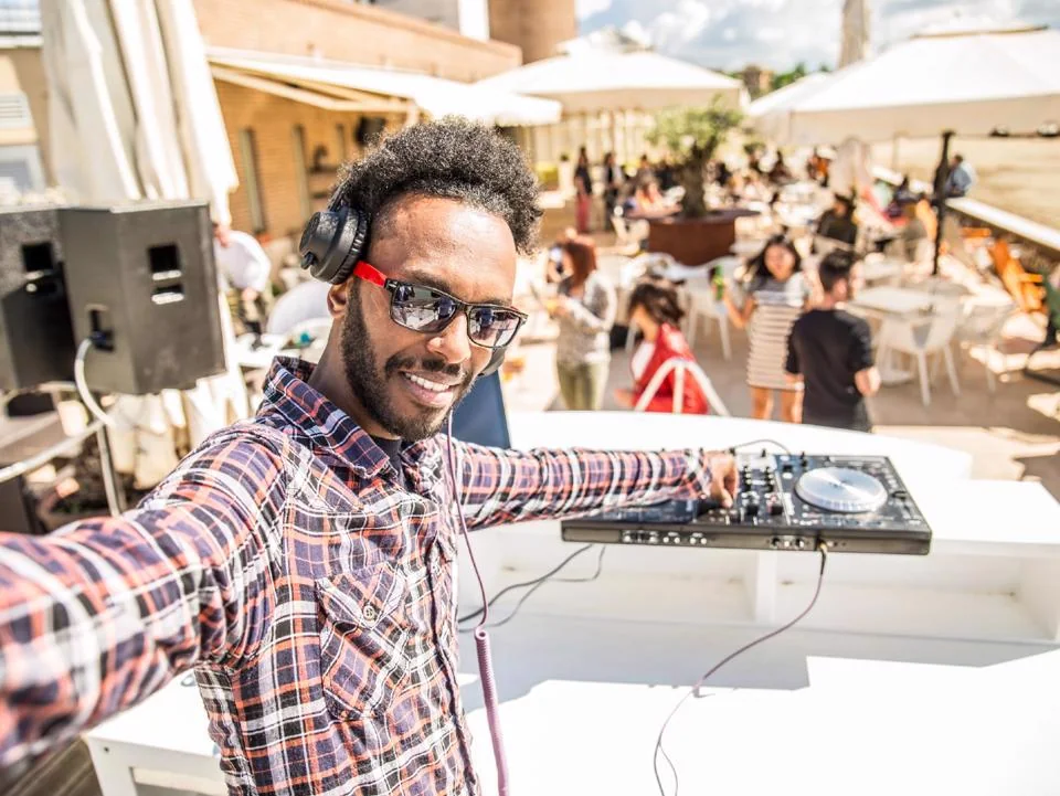 DJ performing at an outdoor block party with guests enjoying the event