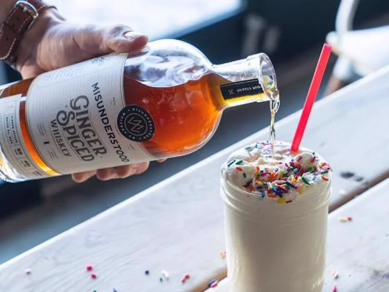 Boozy milkshake topped with whipped cream and colorful sprinkles
