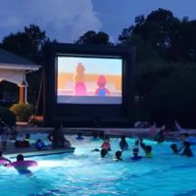 Outdoor movie night with a large inflatable screen at a poolside resident event for an apartment community.