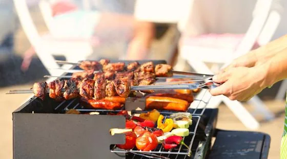 Grilled meat and vegetables prepared for a summer open house event