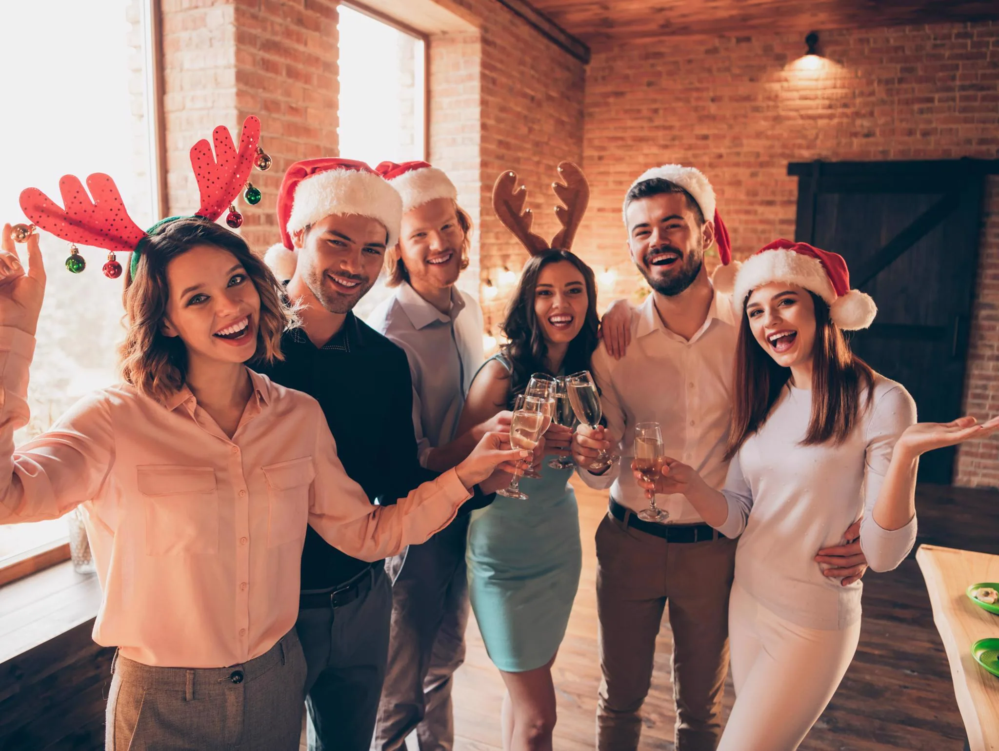 Friends in festive holiday hats celebrating at a Winter Wonderland open house