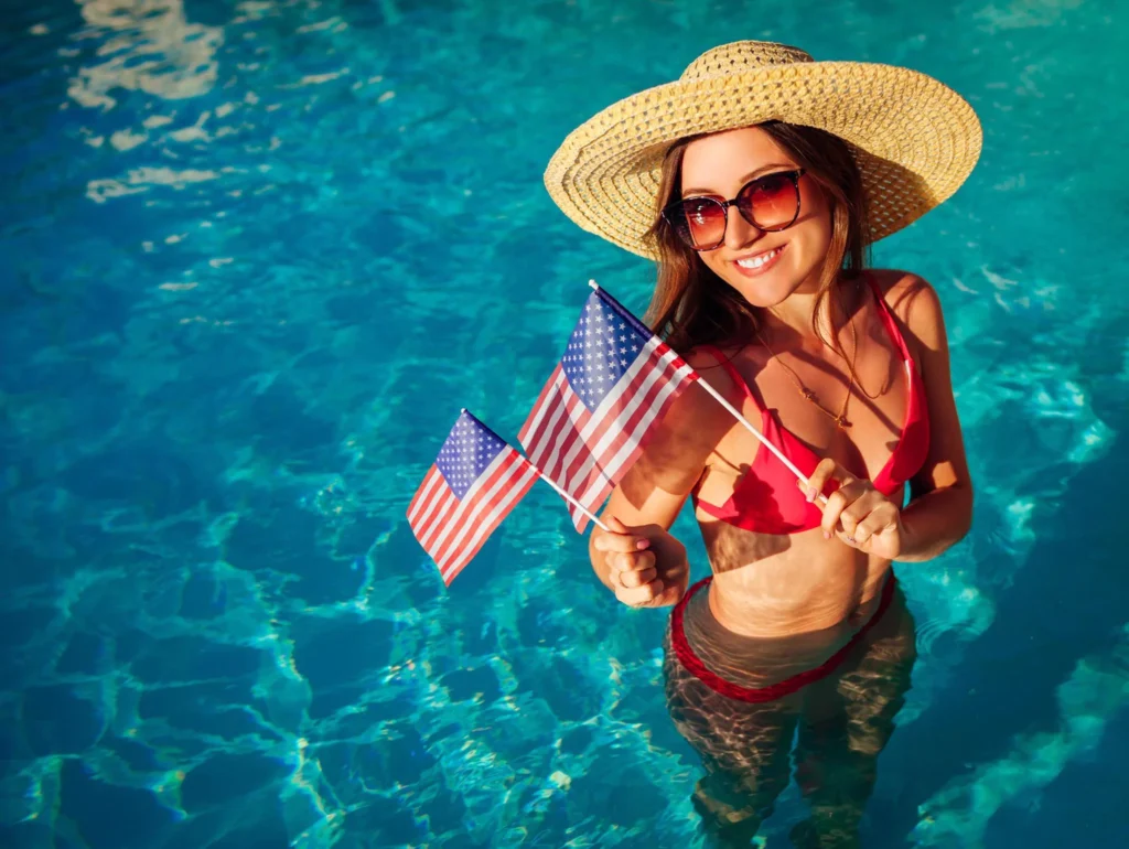 Woman enjoying a 4th of July pool party with American flags
