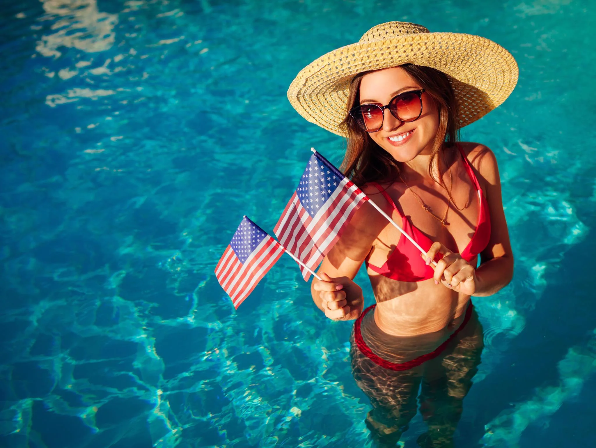 Woman enjoying a 4th of July pool party with American flags