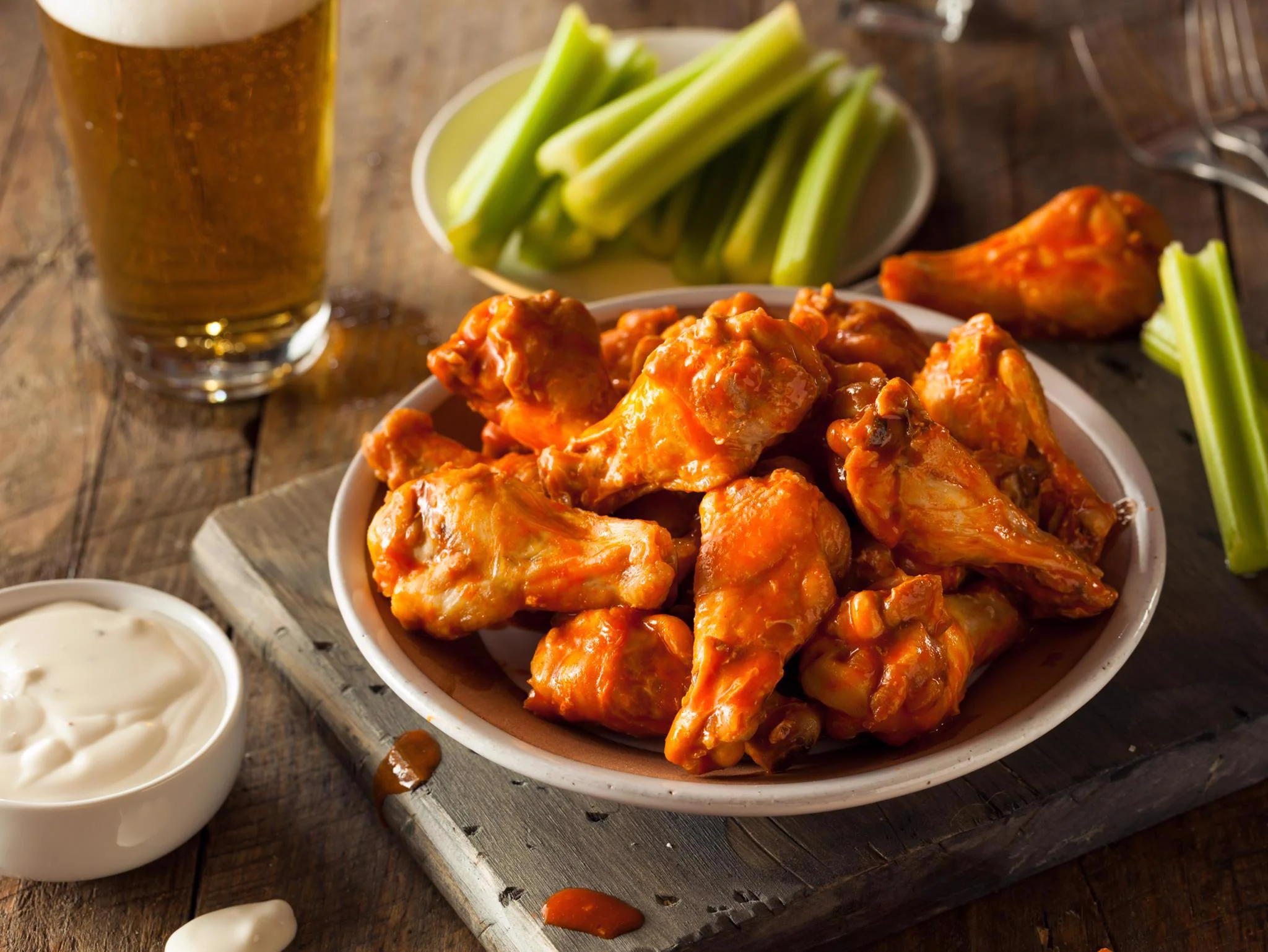 Spicy chicken wings served with celery and beer