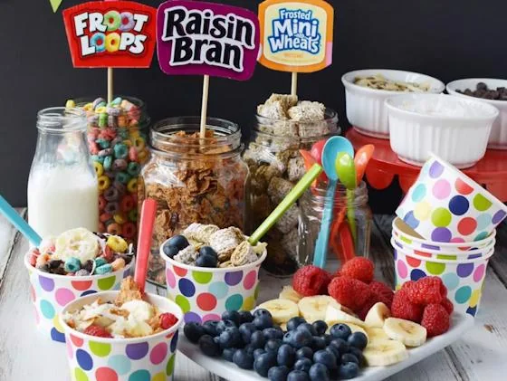 Colorful cereal breakfast bar with fruit, toppings, and milk