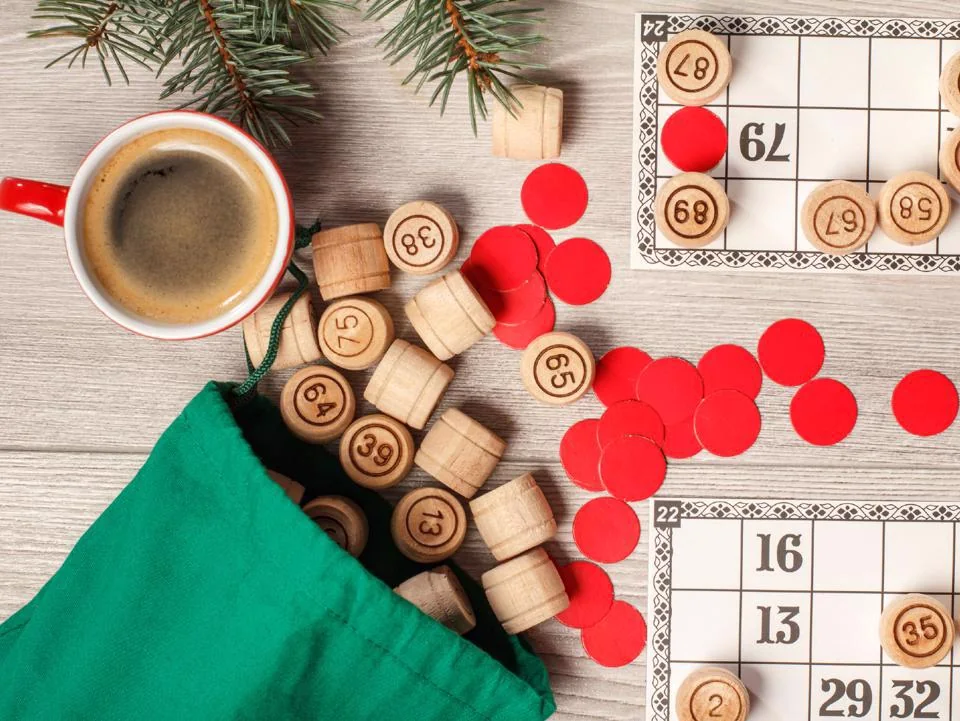 Christmas bingo cards and markers on a festive table