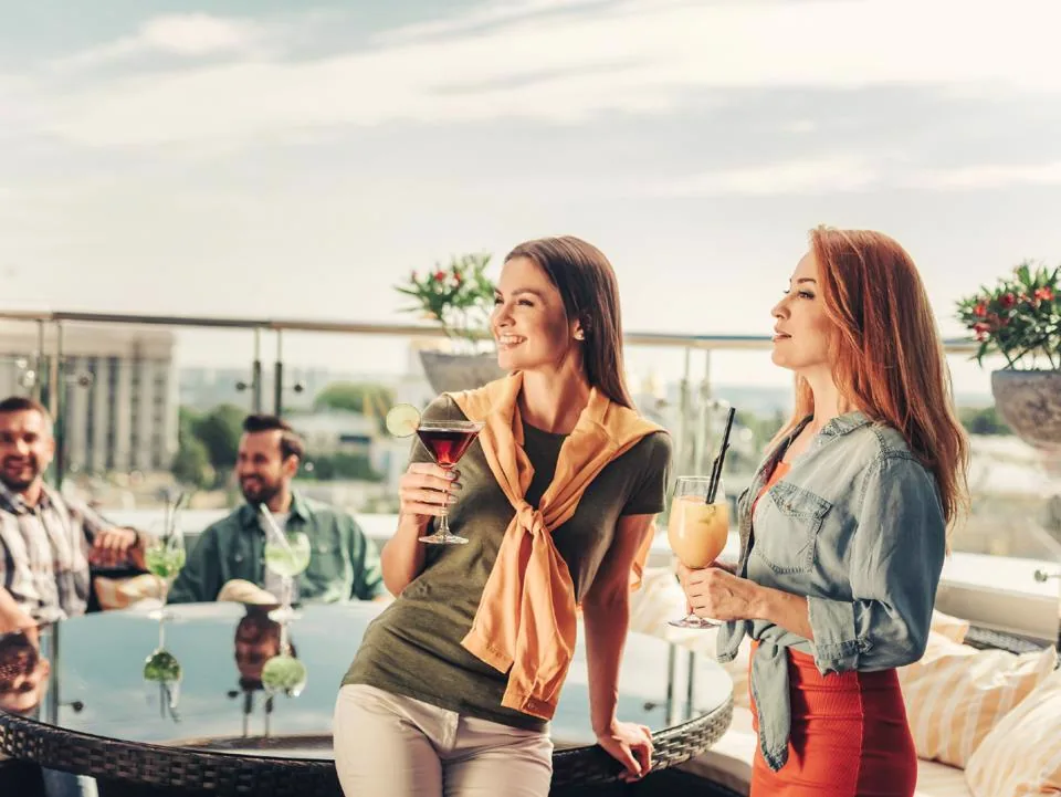 Guests enjoying drinks at a rooftop fall happy hour