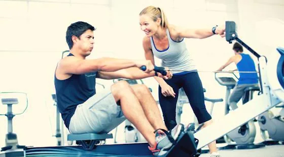 Resident learning how to use fitness center equipment with a trainer