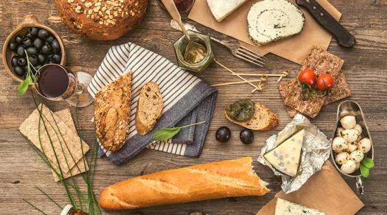 French cheese, bread, olives, and wine arranged on a table