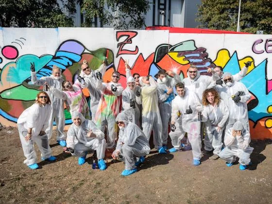 Residents posing in front of colorful graffiti artwork