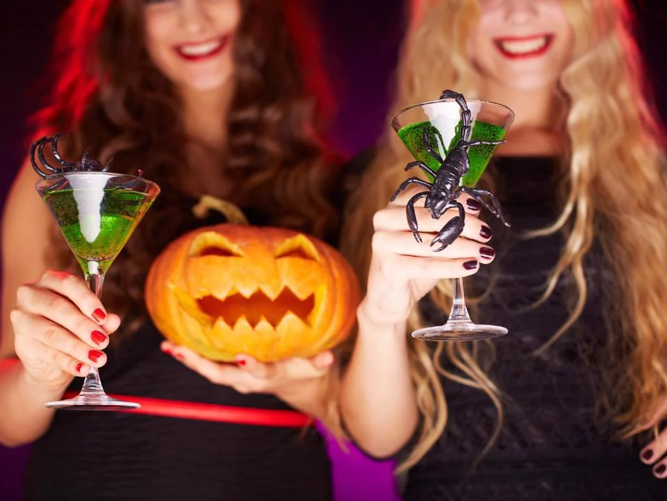 Halloween cocktails served with pumpkins and spooky decorations