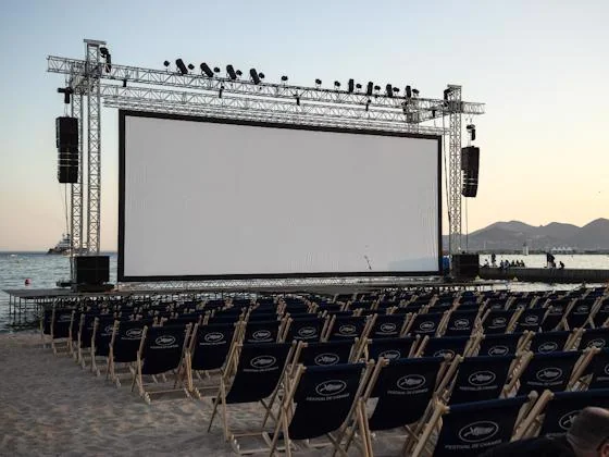 Outdoor movie screen set up on a beach for Halloween