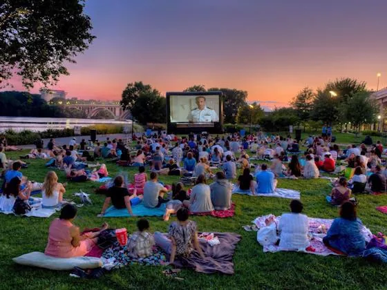 Residents watching an outdoor movie together on a lawn