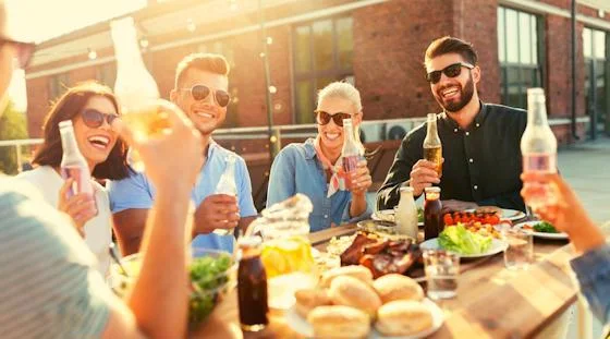 Residents enjoying drinks and food together at an outdoor happy hour