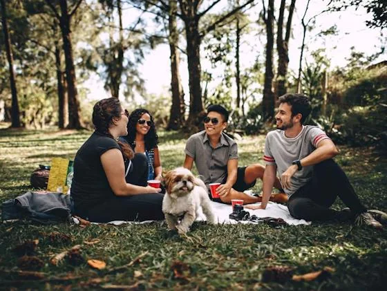 Residents relaxing with a dog at an outdoor Yappy Hour event